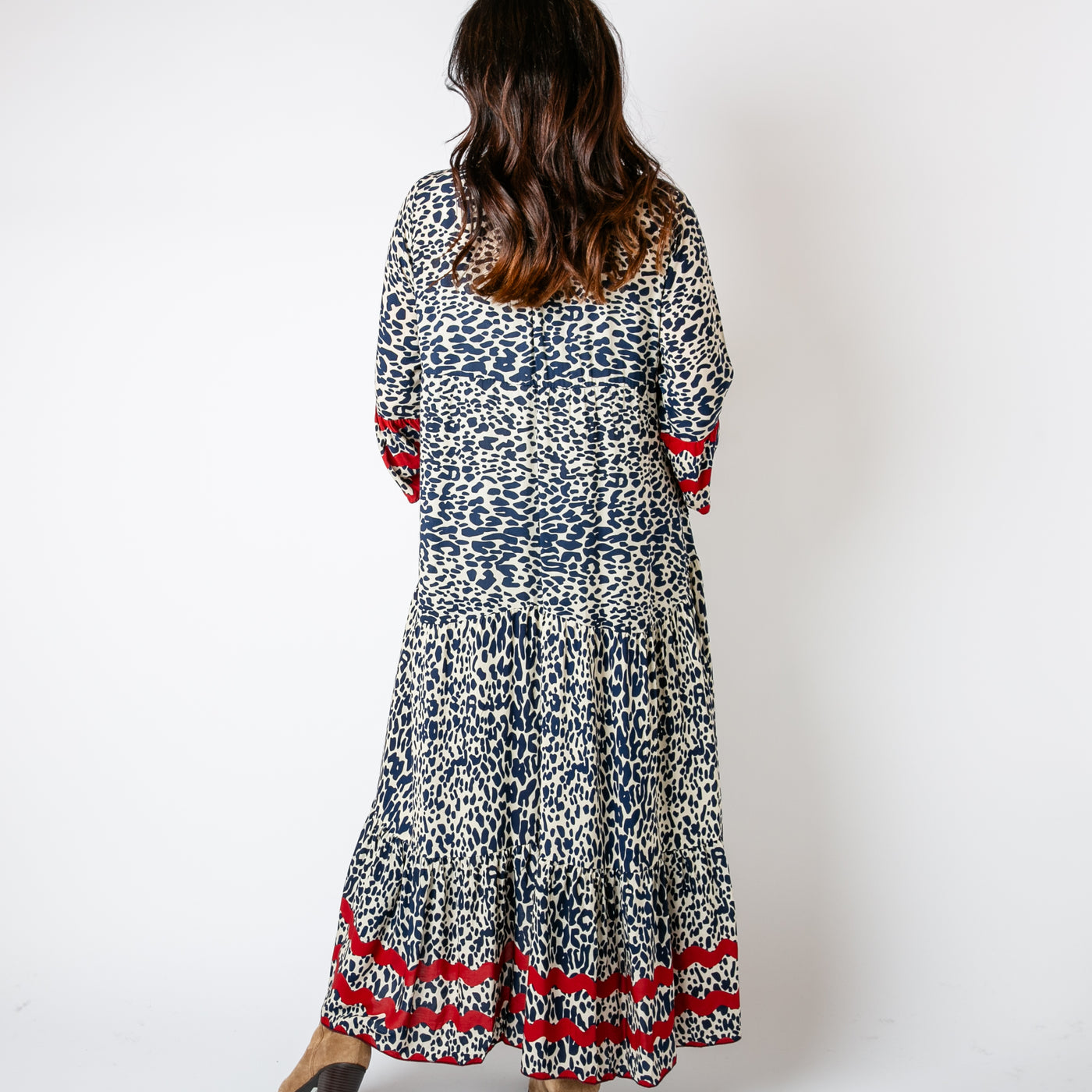 The Wave Trim Tiered Dress in navy blue featuring an irregular spotty pattern with contrasting wave patterns around the sleeves and bottom hemline