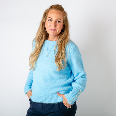 The baby blue Wool Button Jumper made from a blend of recycled polyester and wool