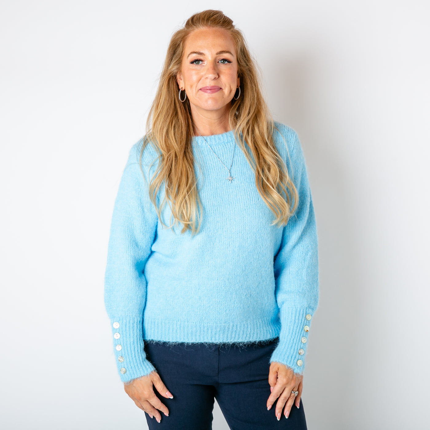 The baby blue Wool Button Jumper with a round crew neckline and long sleeves