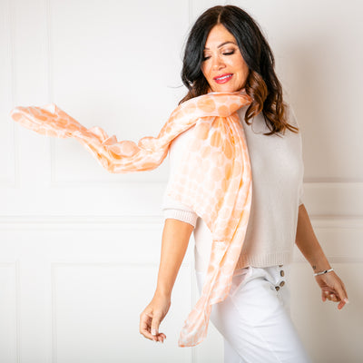 The Coral Spot Silk Scarf worn by a model, loosely over one shoulder 