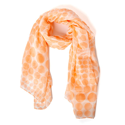 The Coral Spot Silk Scarf featuring a polka dot pattern in. soft shade of orange 