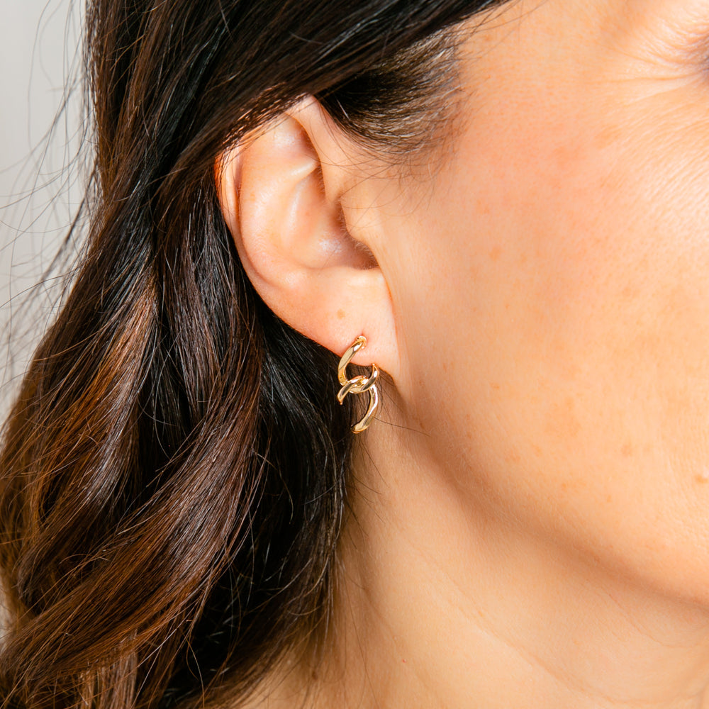 Darby stud earrings shown on model in gold, semi oval link studs.