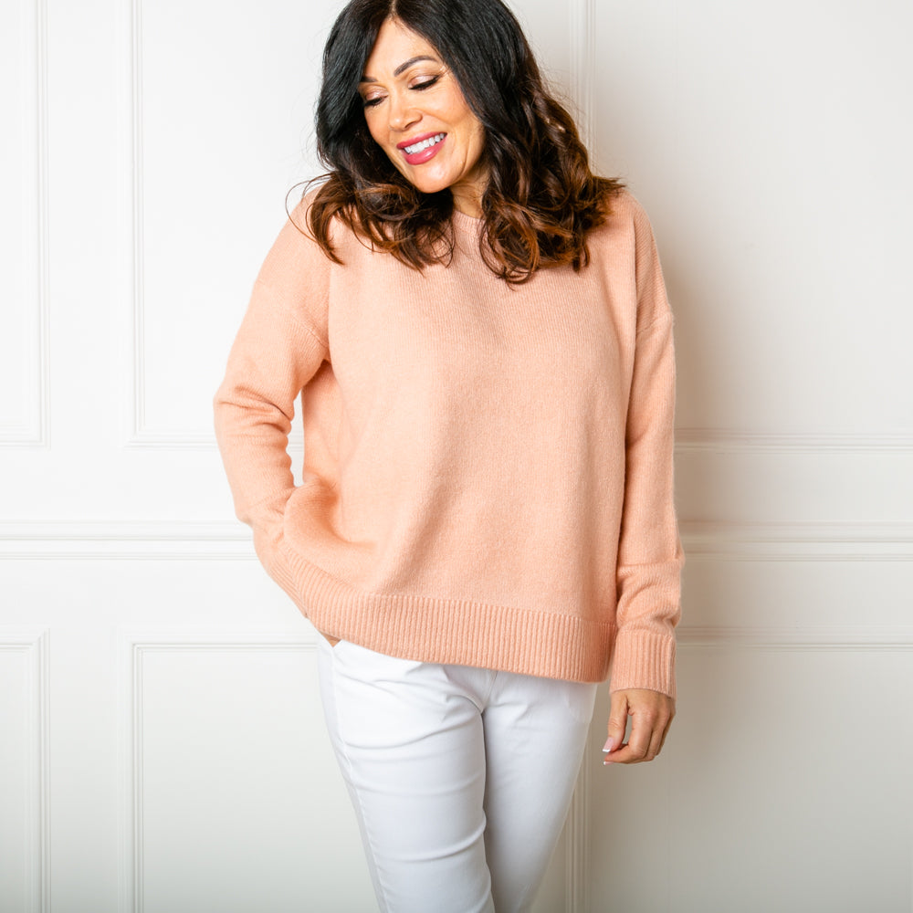 The Essentials Knitted Jumper in peach orange with long sleeves and a round crew neckline