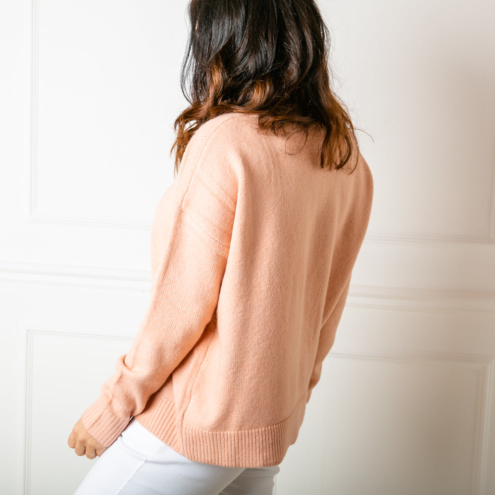 The Essentials Knitted Jumper in peach made from a fine knit acrylic blend material