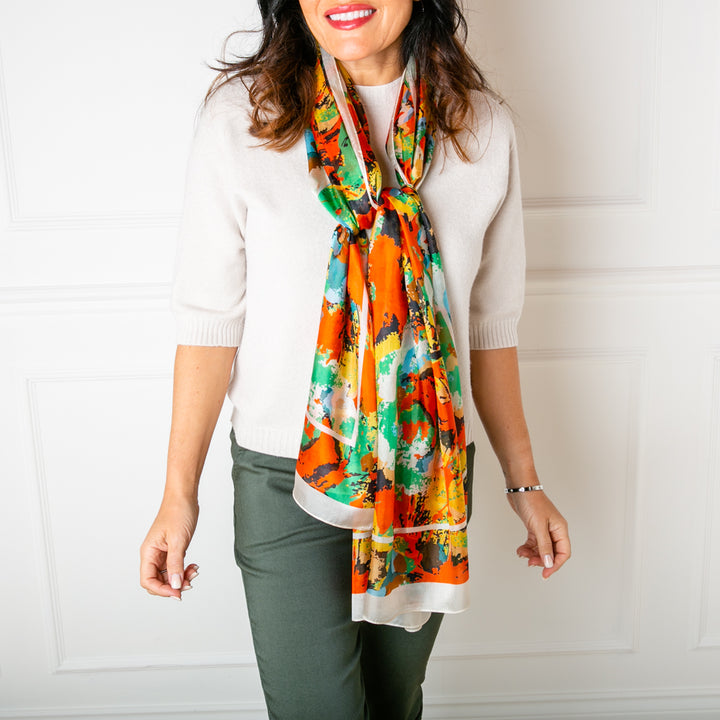 The Flower Paint Brush Silk scarf worn by a model tied loosely over the chest