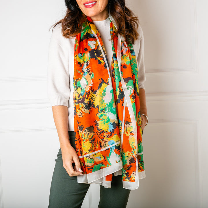 The Flower Paint Brush Silk scarf worn by a model loosely over the shoulders