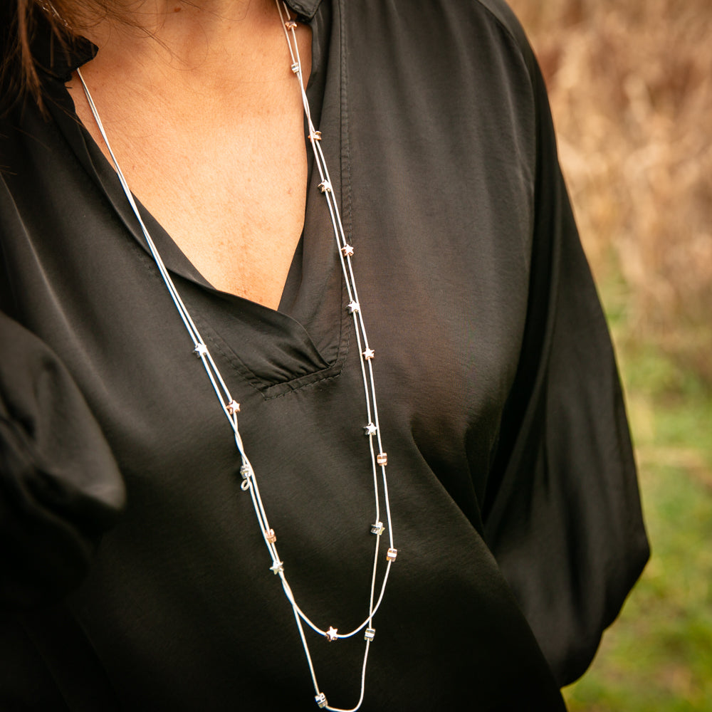Geri necklace shown on model in Silver, long necklace with star pendants