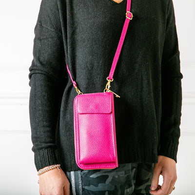 model shot of bright fuchsia India leather handbag with card slots and pocket inside, popper fastening and detachable cross body strap