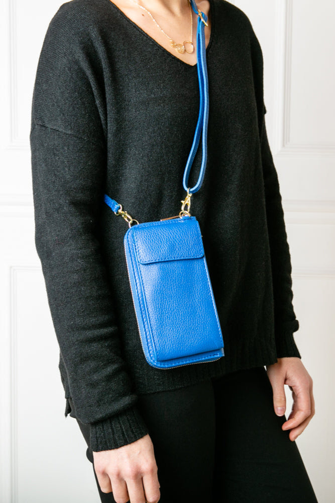 Leather cross body purse. model shot of royal blue India leather bag with card slots and pocket inside, popper fastening and detachable cross body strap