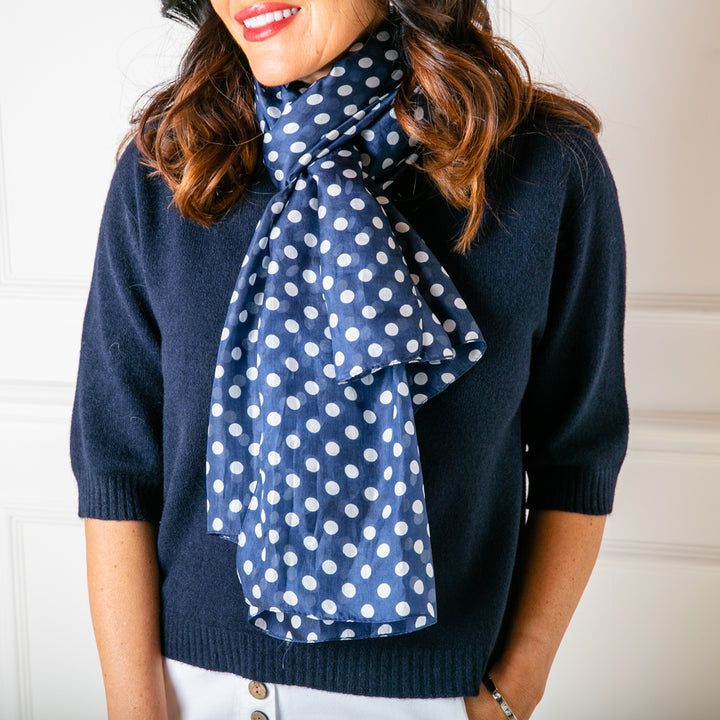 The Polka Dot Silk Scarf worn looped around the models neck