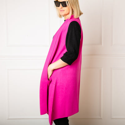 Sleeveless Cardigan in Fuchsia, pockets either side, mid length, women's knitwear, super soft, super cosy, side profile.