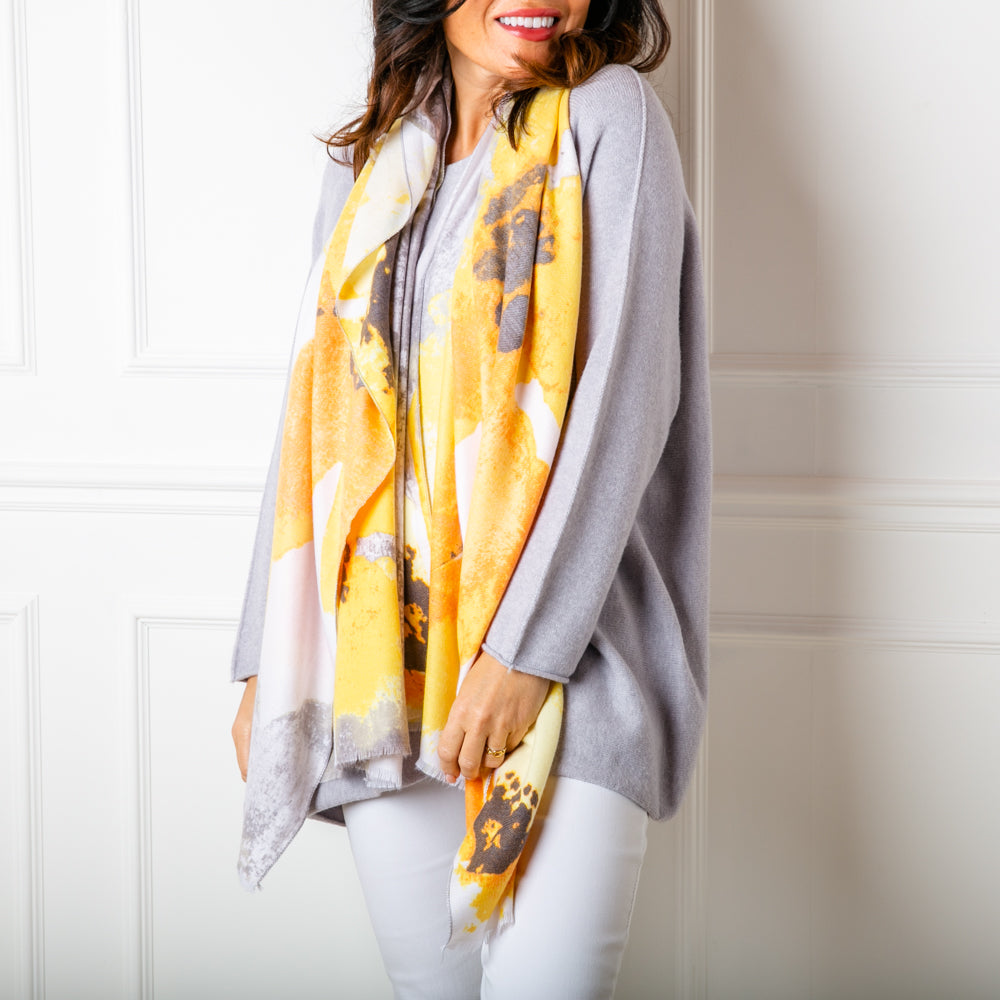 The Tokyo Scarf in yellow worn loosely around the models neck to show the oversized pattern